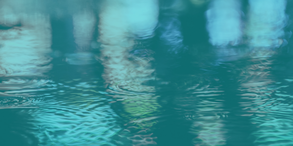 Puddle with reflected street lights, blue and red and green, on sidewalk with blue overlay